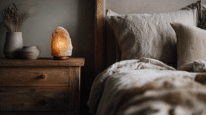 a cozy bedtime scene with a linen covered bed, himalayan salt lamp on bedside table