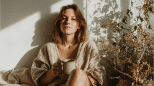 a woman sits peacefully in the morning sunlight with a calm and content expression on her face